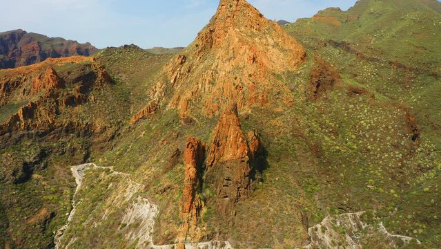Wide aerial view of clay rock. National Teno Park. Golden mountains with light green vegetation in spring. Fantastic area for a hike. Paradise for hikers. Tenerife. Risco Blanco. Nature preserve.