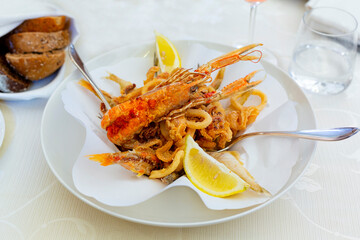  A mixed italian dish of fried in batter seafood. Fritto misto di pesce e lemon.