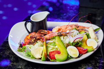 Salad with avocado, tiger prawns, tomatoes and quail eggs