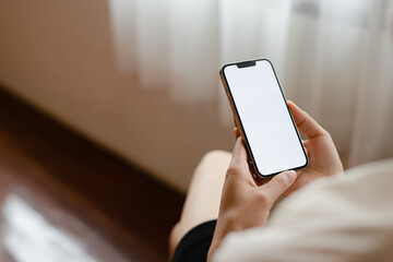 Close-up of a woman's hand holding a cell phone with a dummy copy space screen for your ad content. Asian girl watching web video on mobile phone during vacation.