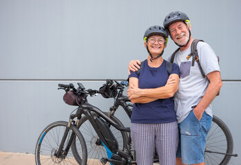 Happy and relaxed senior caucasian couple with helmet enjoying sport activity with electric...