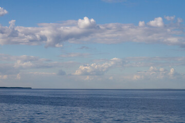 Naklejka na ściany i meble endless blue calm sea or lake with blue sky with white clouds