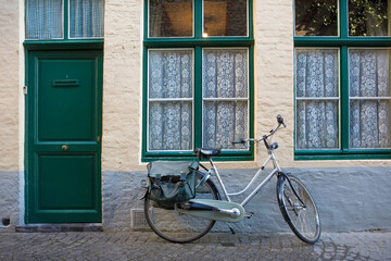 Fototapeta na wymiar Peerdenstraat: a quiet, narrow lane with an old Flemish house and attendant bicycle, Brugge, Belgium