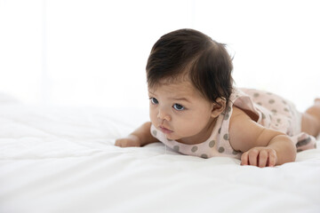 cute baby crawling on bed and drooling from mouth