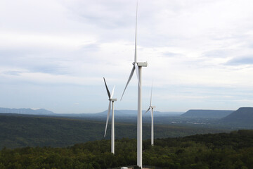 Aerial view of windmills in green forest in Thailand. Wind turbines for electric power with clean and Renewable Energy