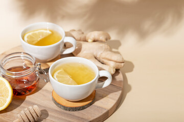  Cup of hot tea with ginger, honey and lemon on the beige background copy space for text