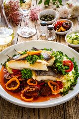 Fish dish - fried halibut with potato puree, fried pepper and chorizo on wooden table
