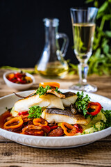 Fish dish - fried halibut with potato puree, fried pepper and chorizo on wooden table
