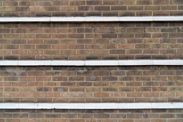Closeup facade glazed bricks three cornices background