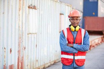 portrait African factory worker or engineer folded arms pose in containers warehouse storage