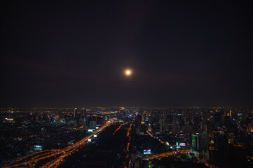 Bangkok.thailand.16.04.2022:Bangkok cityscape view with beautiful full moon  from top of building in bangkok city