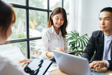 Group of asian young creative happy people entrepreneur on a business meeting office background Good leadership and teamwork lead to success working with financial report.