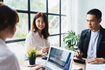 Asian business woman present and explain work to female colleague, using laptop computer in office,...