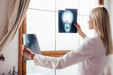 Female doctor examines skull scans in office