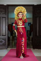 Fototapeta na wymiar A female model who wears make-up and a traditional wedding dress or attire. Traditional clothing of Bali - Indonesia. Balinese Culture