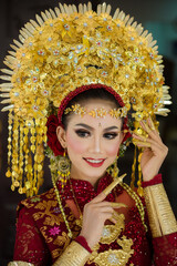 A female model who wears make-up and a traditional wedding dress or attire. Traditional clothing of Bali - Indonesia. Balinese Culture