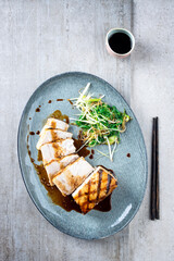 Traditional barbecue swordfish steak teriyaki with vegetable and soy sauce served as top view on a...