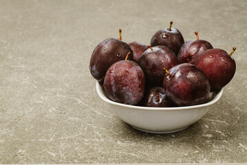 Washed ripe plums in a plate for eating