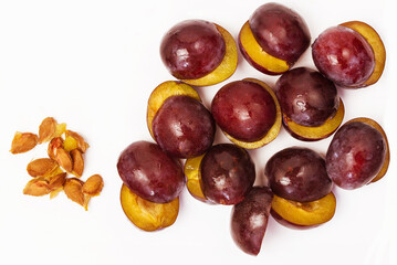 Cut halves of pitted plums isolated on white