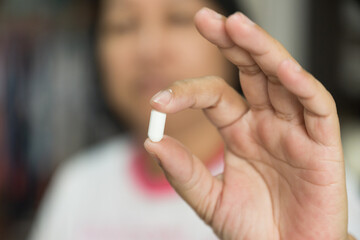 Close up woman hand putting white pill.Sick female holding pill for taking medicines,...