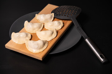 Fototapeta na wymiar freshly prepared dumplings with kitchen utensils