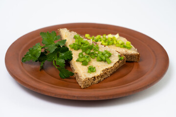 a slice of bread smeared with lard with green onions and parsley