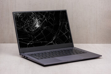 laptop with a broken screen in cracks on a gray background close up with clipping path - 524901260