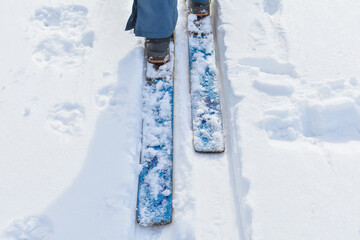 man on skis designed to move through snowdrifts. Winter sports, walking. Wooden vintage skis on snow