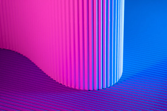 Abstract geometric background with magenta and blue hues. Corrugated lines futuristic backdrop.