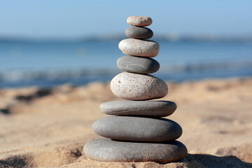 Fototapeta na wymiar Stack of stones on beautiful sandy beach