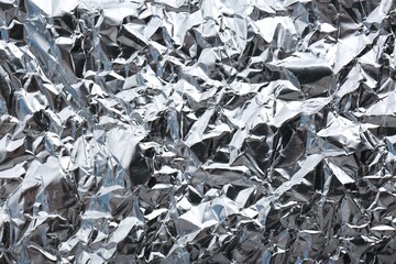 Crumpled silver foil as background, closeup view