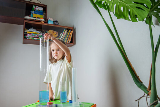 Child drips a colored liquid with a pipette into a test tube. A chemise experience at home. Homeschooling and distance education. Back to school
