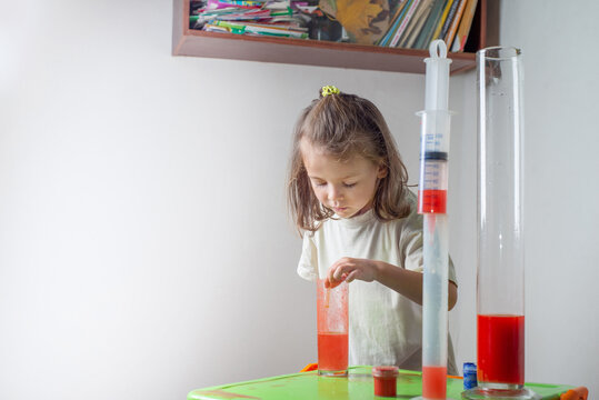 Child drips a colored liquid with a pipette into a test tube. A chemise experience at home. Homeschooling and distance education. Back to school concept