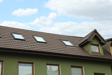 Beautiful house with brown roof against blue sky, low angle view