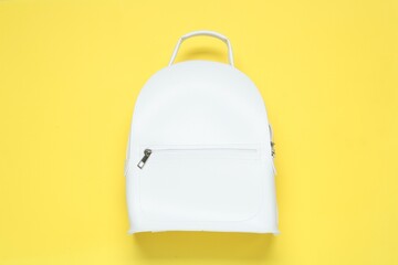 Stylish urban backpack on yellow background, top view