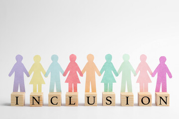 Paper human figures and wooden cubes with word Inclusion on white background