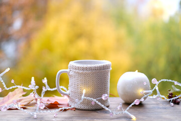 beverage, coffee in a mug, leaves, foliage, candles on wooden table in garden, beautiful blurred...