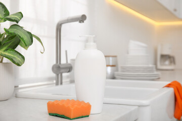 Cleaning product with sponge near sink in stylish kitchen
