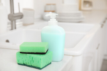Cleaning product with sponge near sink in stylish kitchen