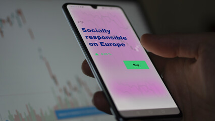 An investor's analyzing the socially-responsible on Europe etf fund on screen. A phone shows the ETF's prices ESG esg equities EU to invest