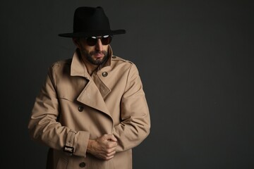 Exhibitionist in coat and hat on black background. Space for text