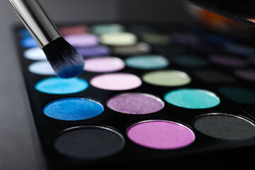 Colorful eyeshadow palette with brush, closeup view