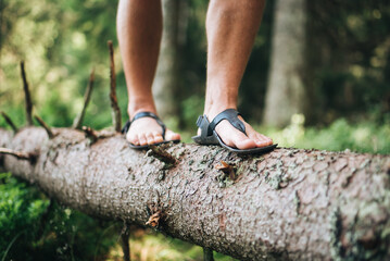 Man walking in barefoot shoes in the forest. Healthy lifestyle. Feeling nature with the feet. 