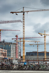 The city of Copenhagen is under construction. Several cranes are used in a large construction cite....