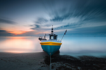 Baltic see, surise over beach and boat. Sopot, morze bałtyckie. Wschód słońca nad kutrem rybackim z widokiem na morze i plażę  - obrazy, fototapety, plakaty