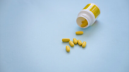 Assorted pharmaceutical medicine pills, tablets and capsules over blue background