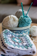 blue and white wool with granny square and crochet hook in box with flowers nordic style
