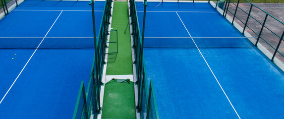 two blue synthetic grass paddle tennis courts