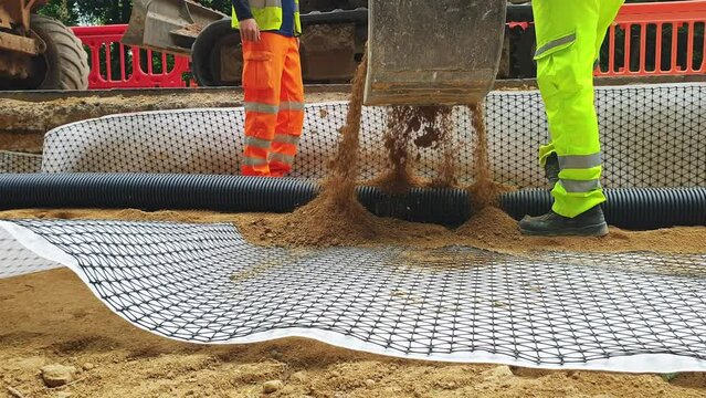 Groundworkers installing new electric ducts during roadworks