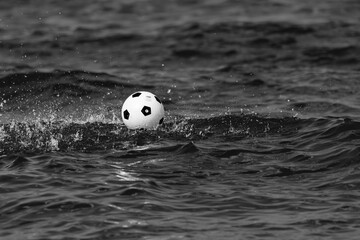biała czarna piłka w wodzie na morzu na falach